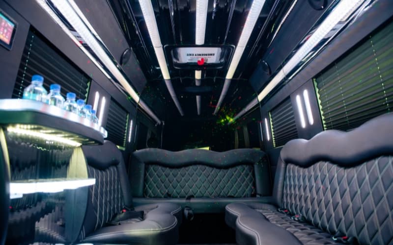 Mercedes Executive Sprinter Limo interior with diamond-stitched perimeter seating, neon fiber optic lighting, and built-in bar