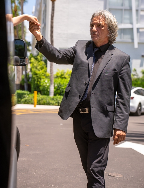 Professional Miami chauffeur assisting passenger
