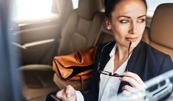 businesswoman holding glasses in back of luxury car businesswoman holding glasses in back of luxury car